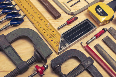 High angle view of various work tools on wooden table