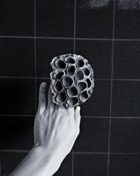 Close-up of hand holding umbrella on tiled floor