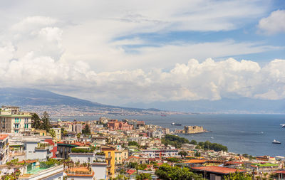 High angle view of townscape by sea against sky