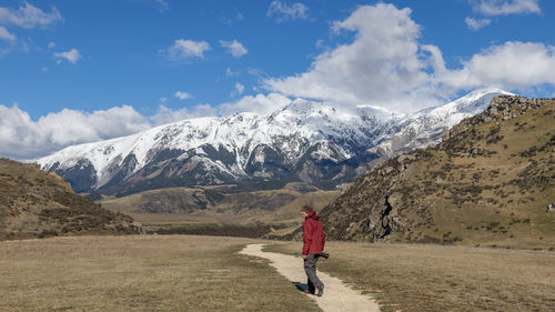 Rear view of woman walking on mountain against sky