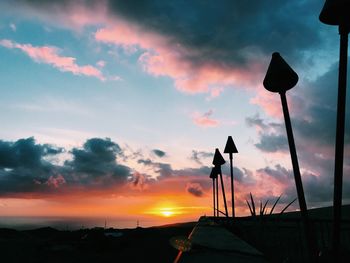 Low angle view of silhouette crane against sky during sunset
