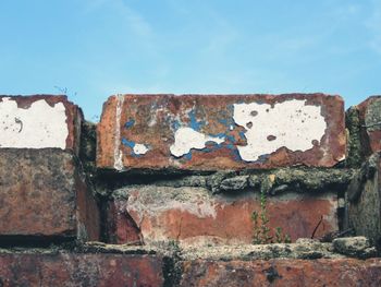 Close-up of rusty brick wall against sky