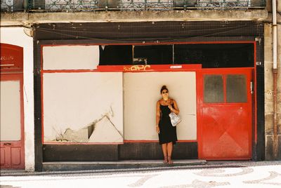Full length of woman standing against door