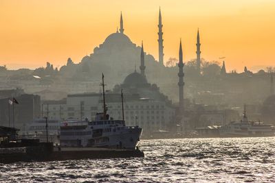 View of mosque and buildings against sky during sunset