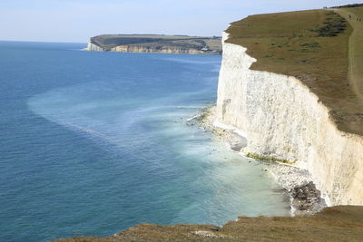 Scenic view of cliffs and sea against sky