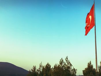 Low angle view of flag against clear blue sky