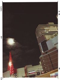 Low angle view of modern skyscraper against sky at night