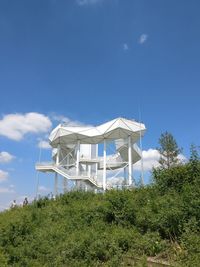 Traditional windmill on landscape against clear blue sky