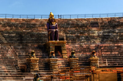 Low angle view of statue on staircase against brick wall