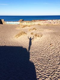 Shadow of woman on sand at beach