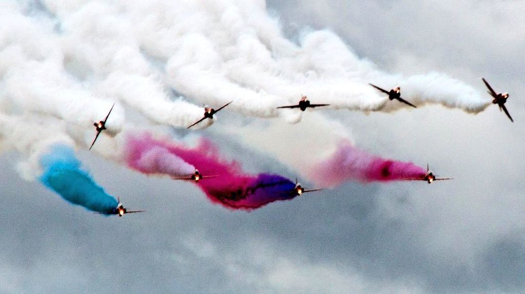 LOW ANGLE VIEW OF AIRSHOW IN FLIGHT AGAINST SKY