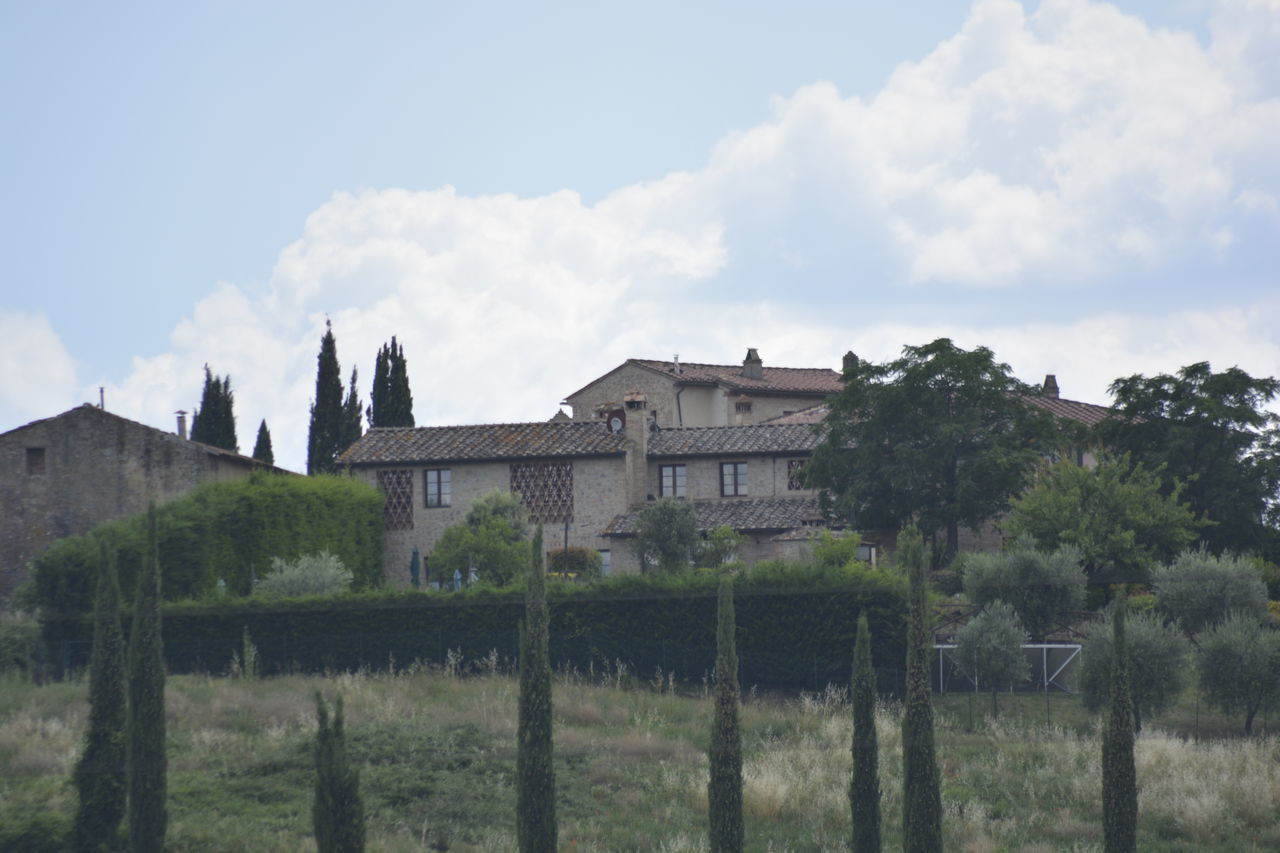 HOUSES ON FIELD AGAINST SKY