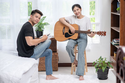 Young man playing guitar at home