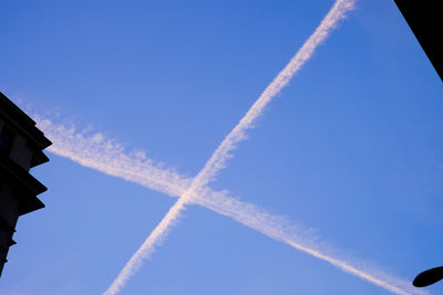 Low angle view of vapor trail against clear blue sky