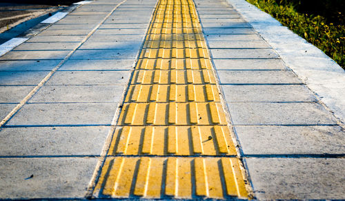 High angle view of yellow road marking on footpath