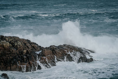 Scenic view of sea waves splashing on rocks