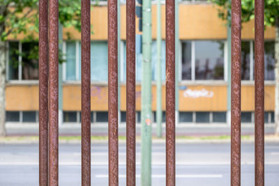 Close-up of metallic rods against road and buildings