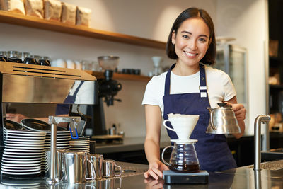 Portrait of young woman standing in cafe