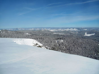 Scenic view of snow covered landscape against blue sky