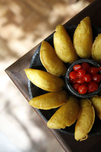 High angle view of meat pastry with red peppers in bowl on table