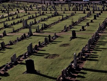 High angle view of tombstones in cemetery during sunny day