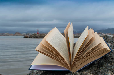 Close-up of open book against sky