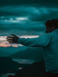 Man raising hand on sunrise background