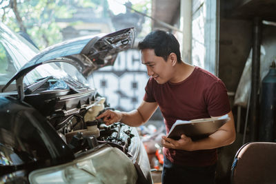 Side view of man holding car