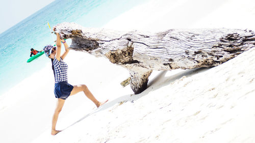 Woman standing on beach by sea against sky