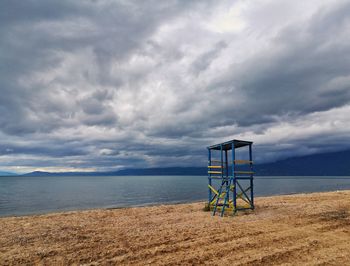 Lifeguard hut on beach against sky