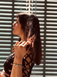 Portrait of woman standing against window