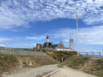 Lighthouse by sea against sky