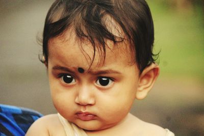 Close-up of cute baby boy looking away