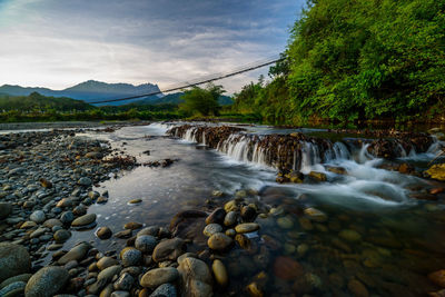 Scenic view of waterfall against sky