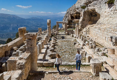 People in front of old ruins against sky