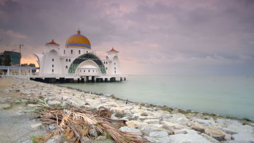 Building by sea against sky