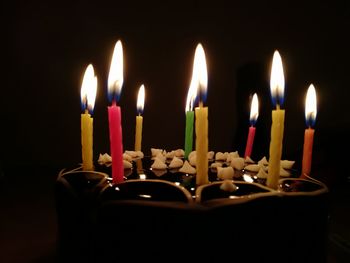 Close-up of burning candles in darkroom