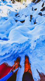 Low section of person on snow covered snowcapped mountain