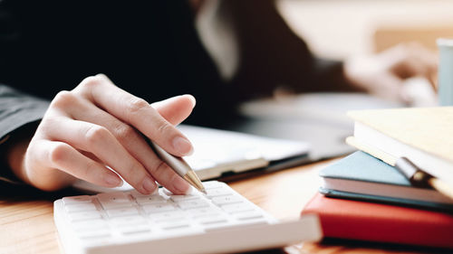 Cropped image of woman reading book on table