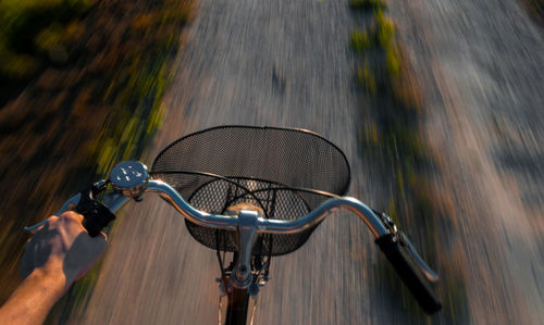 Close-up cropped hand riding bicycle on road