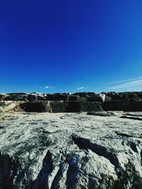 Scenic view of rocks against clear blue sky