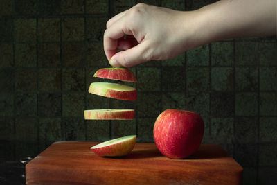 Close-up of hand holding fruit on table