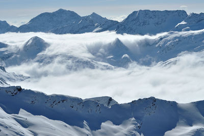 Snow covered high mountains, fog and clouds raising from above. alps, austria