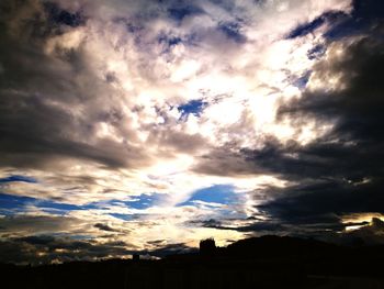 Silhouette of tree against cloudy sky