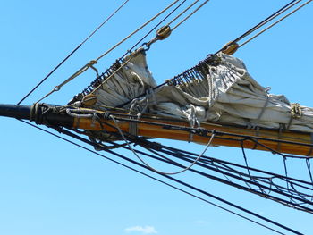 Low angle view of electricity pylon against clear blue sky