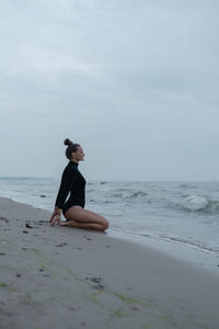 Full length of woman on beach against sky