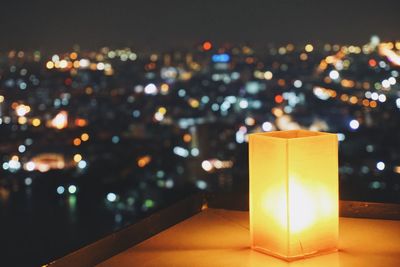 Close-up of illuminated light on table against sky at night