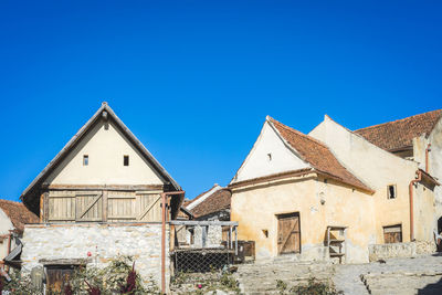 Low angle view of old building against clear blue sky