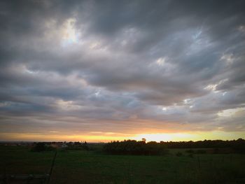 Scenic view of dramatic sky over land during sunset