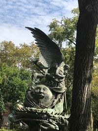 Low angle view of statue against tree trunk